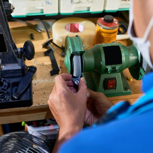 Carpenter polishing small detail in special machine